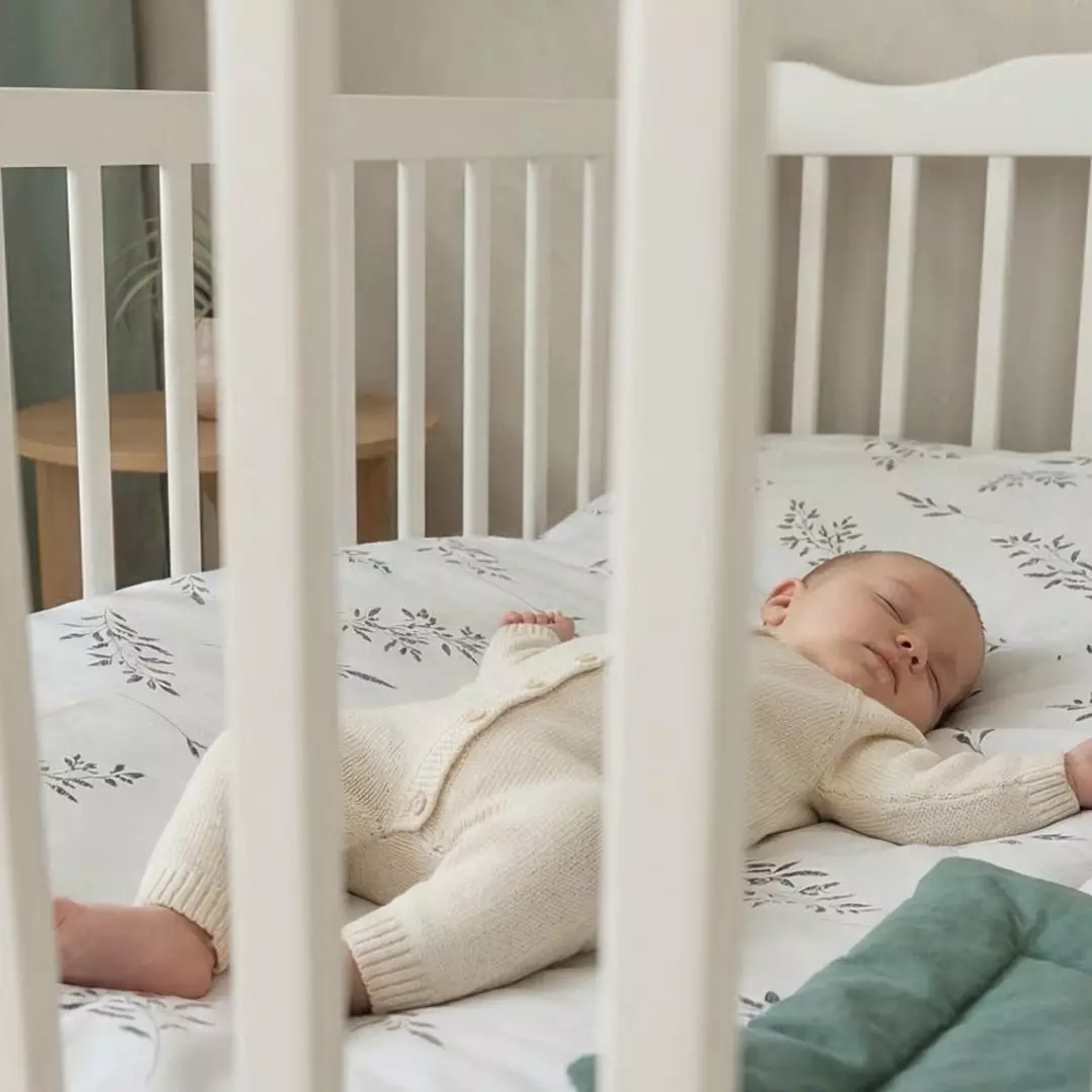 Niemowlę śpiące spokojnie na miękkiej, bawełnianej pościeli